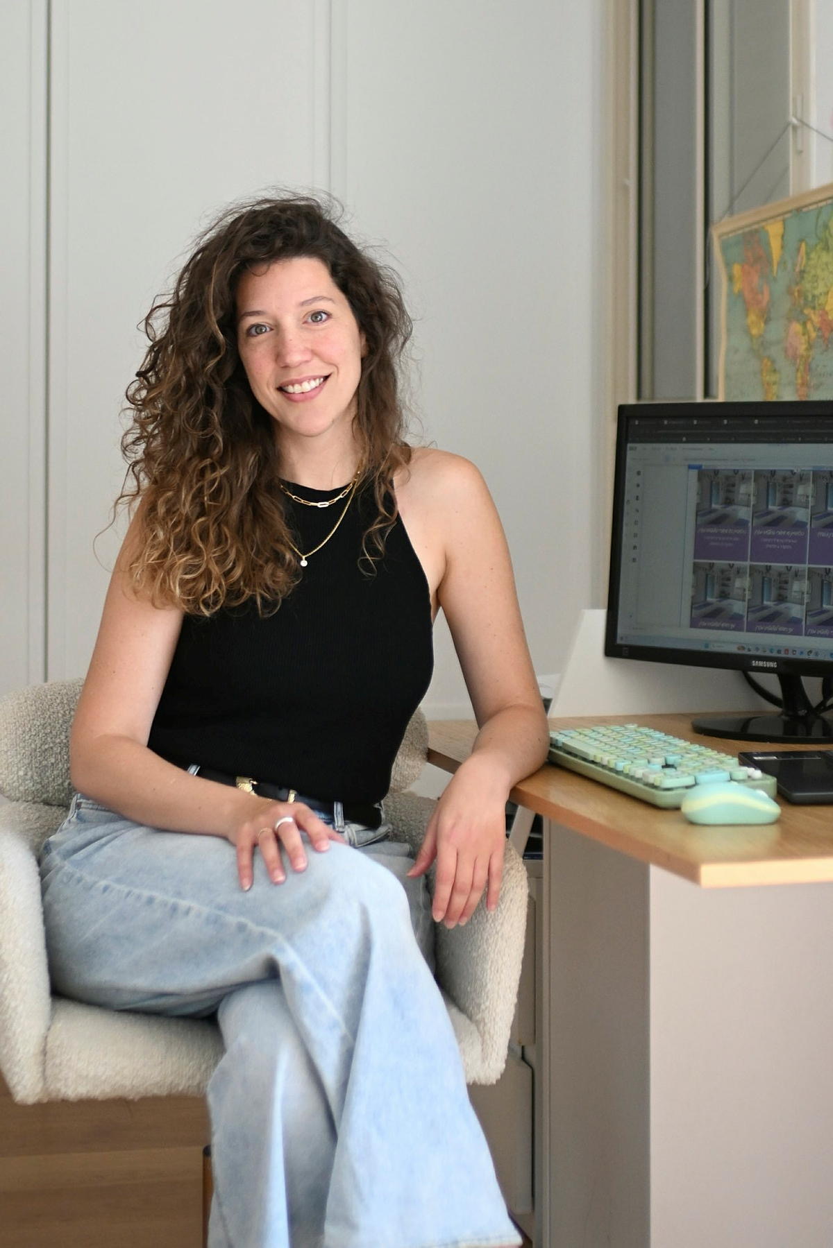 דנה וסרמן מחייכת ליד שולחן העבודה שלה